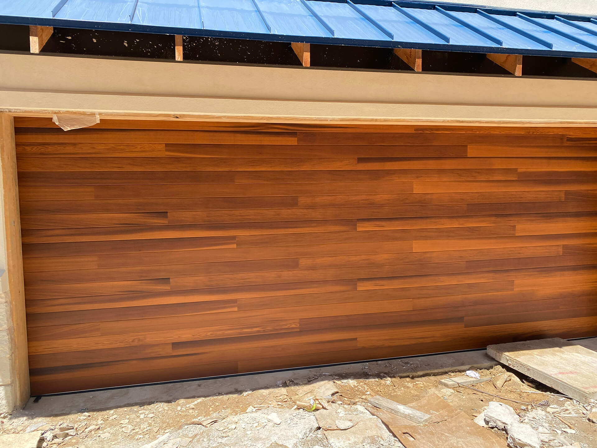Carriage-style wood-tone garage door installed by Door Pro Plus in Marble Falls, TX