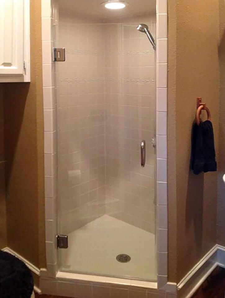 Older framed corner shower door with a metal frame — the style Door Pro Plus commonly replaces with frameless glass in Marble Falls bathrooms