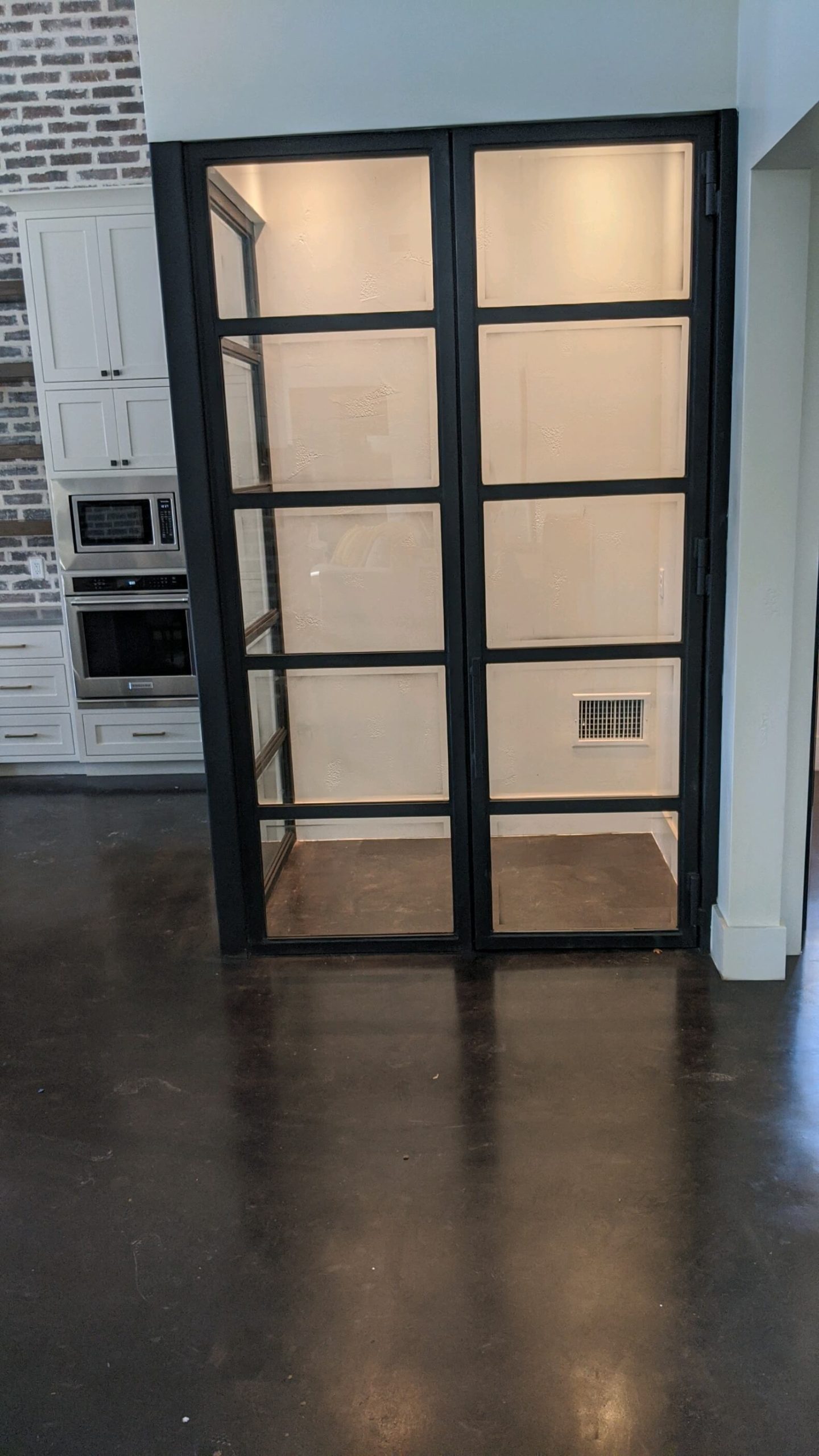 Custom black-framed glass interior doors dividing a kitchen and pantry, installed by Door Pro Plus in a Marble Falls, TX home