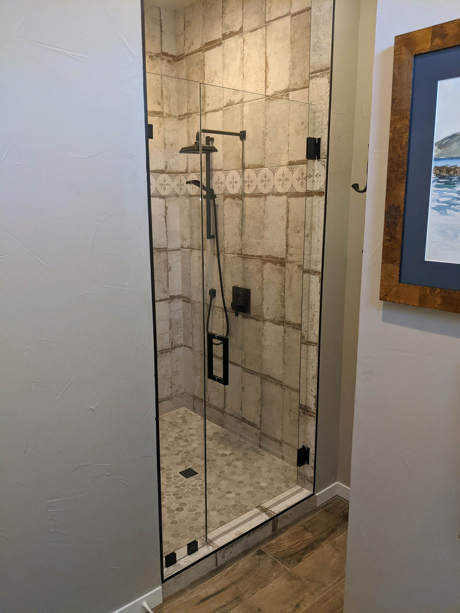 Frameless glass shower door with matte black hardware installed by Door Pro Plus in a Marble Falls, TX bathroom
